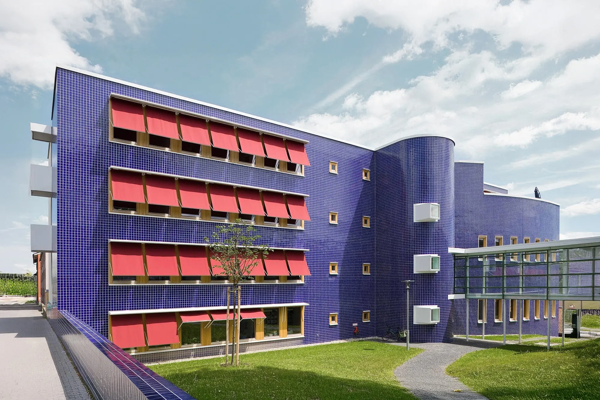 Violettes Bürogebäude mit roten horizontalen Sonnenschutzelementen