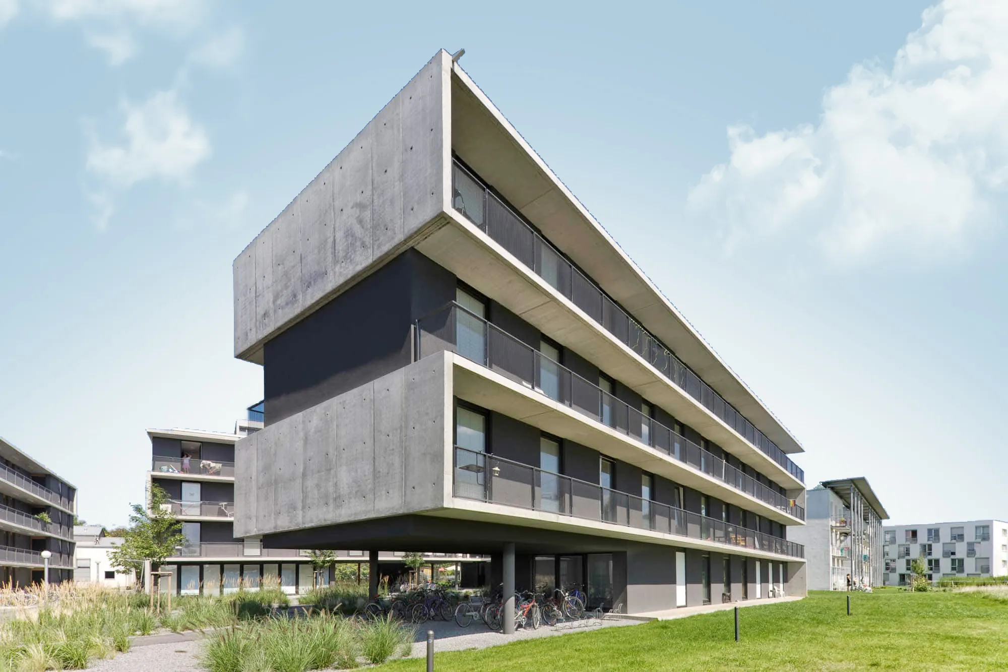 Gestaffeltes Bürogebäude mit horizontalen Fassadenbändern und Grünfläche