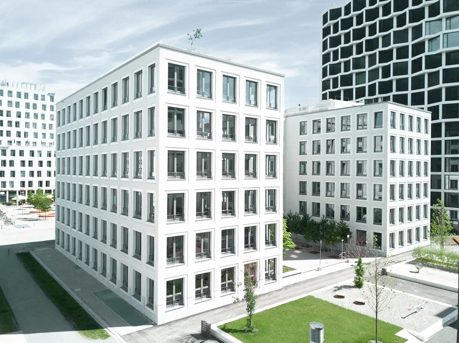 Weiße Bürogebäude mit tiefen Fensterlaibungen und Innenhof