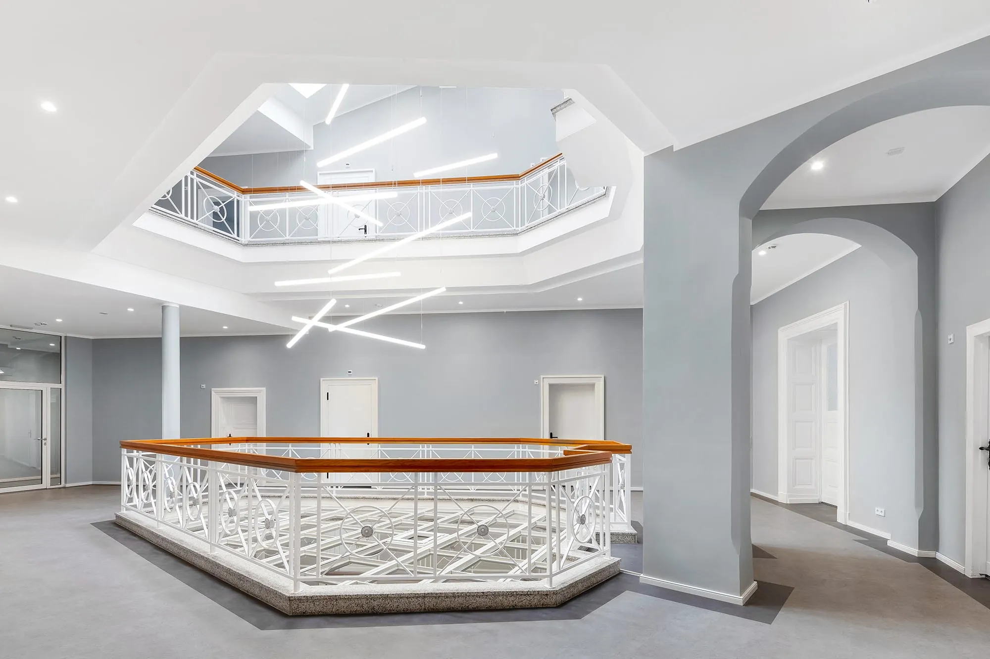 Helle Empfangshalle mit dekorativem Tresen und geschwungenen Galerien